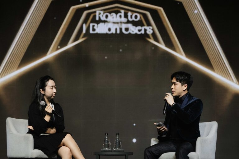 Sarah Song, Head of Business Development at BNB Chain, and Varit Bulakul, President of Business Consulting at The Brooker Group PCL, in conversation on stage under a screen reading "Road to 1 Billion Users".