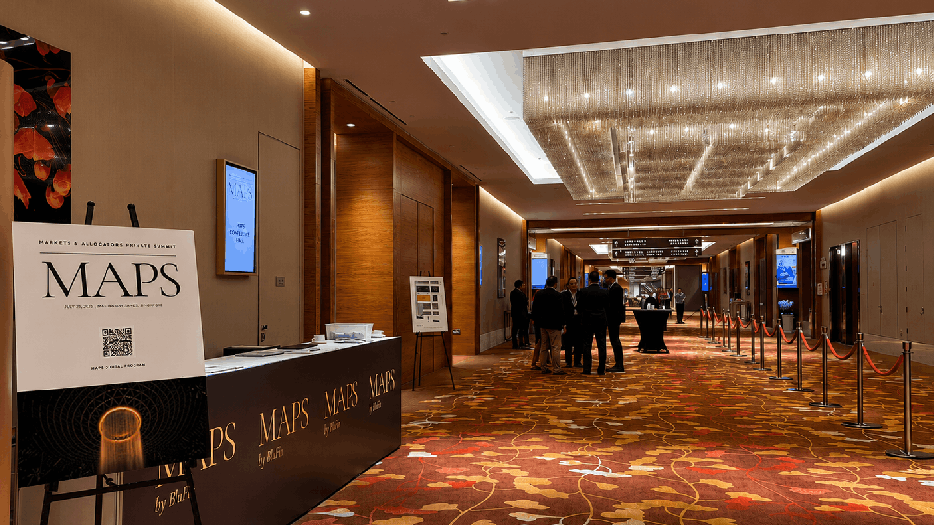 Registration desk and entrance hallway for the MAPS by BluFin summit at Marina Bay Sands, featuring a welcome sign and attendees networking in the distance.