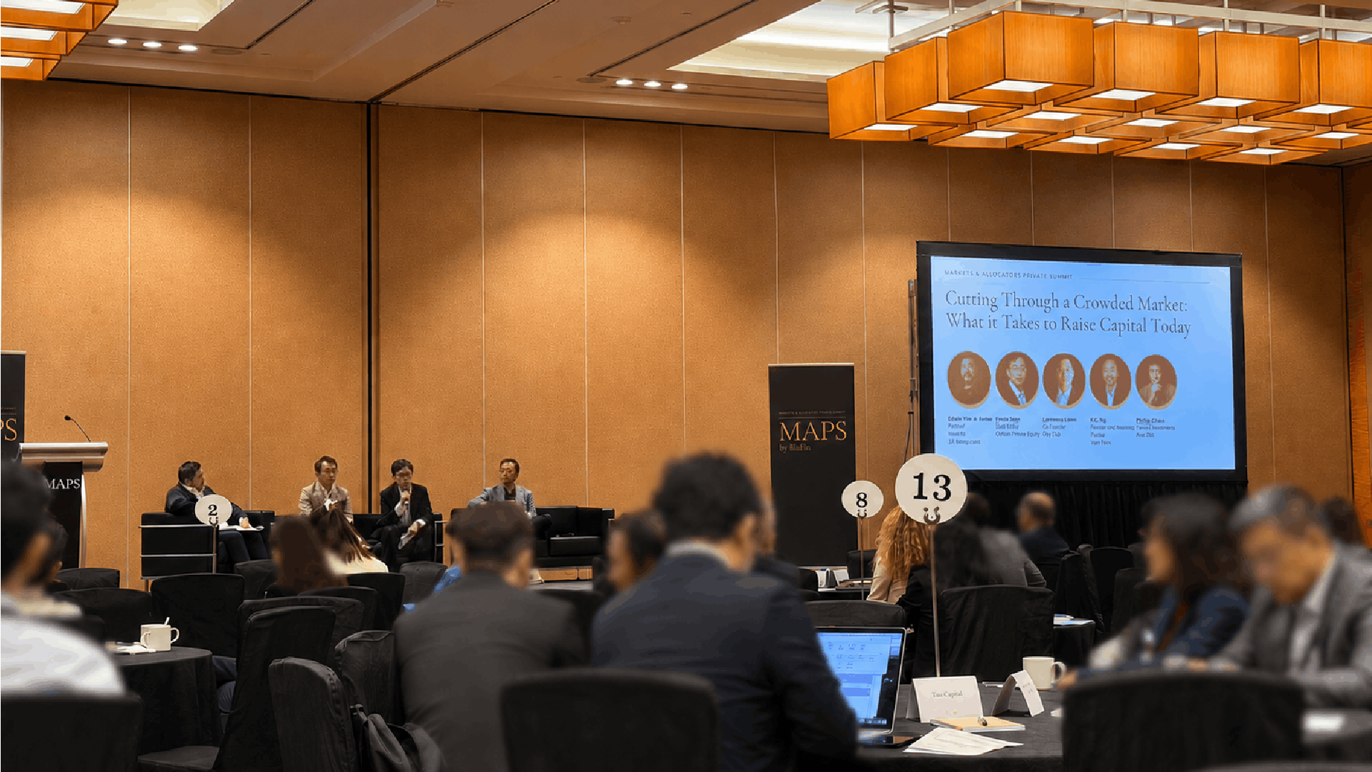 Four panelists seated on stage speaking to an audience at the MAPS by BluFin summit, with a presentation screen titled "Cutting Through a Crowded Market: What it Takes to Raise Capital Today."