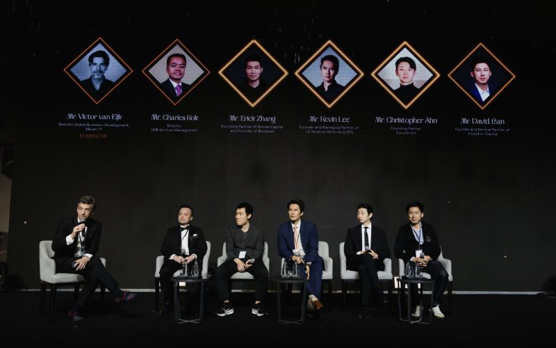 Panel discussion at BNB 1K Gala Night featuring moderator Victor van Eijk and panelists Charles Kok, Erick Zhang, Kevin Lee, Christopher Ahn, and David Gan seated on stage.